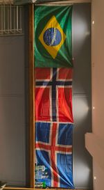 an image of three flags - Brazil, Norway, and Finland, hanging above a wall in the Scoundrels Grappling Dojo